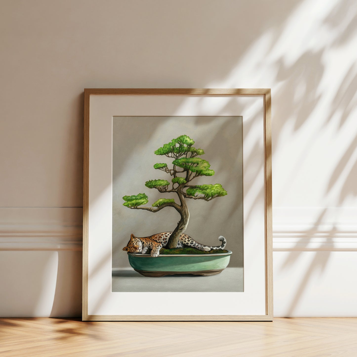 Framed fine art print of a sleeping leopard nestled in a green bonsai pot with a lush tree.
