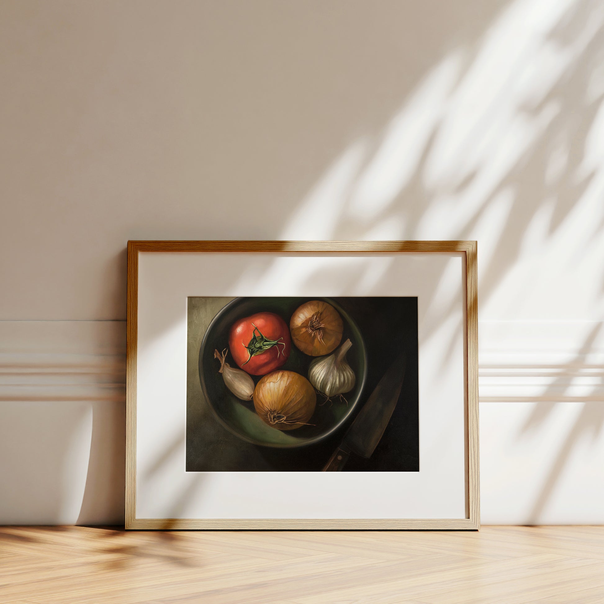 Bowl of Veggies Fine Art Print by Lauren Pretorius: a bowl of veggies from above containing a tomato, onions, garlic and a chefs knife in the shadow.