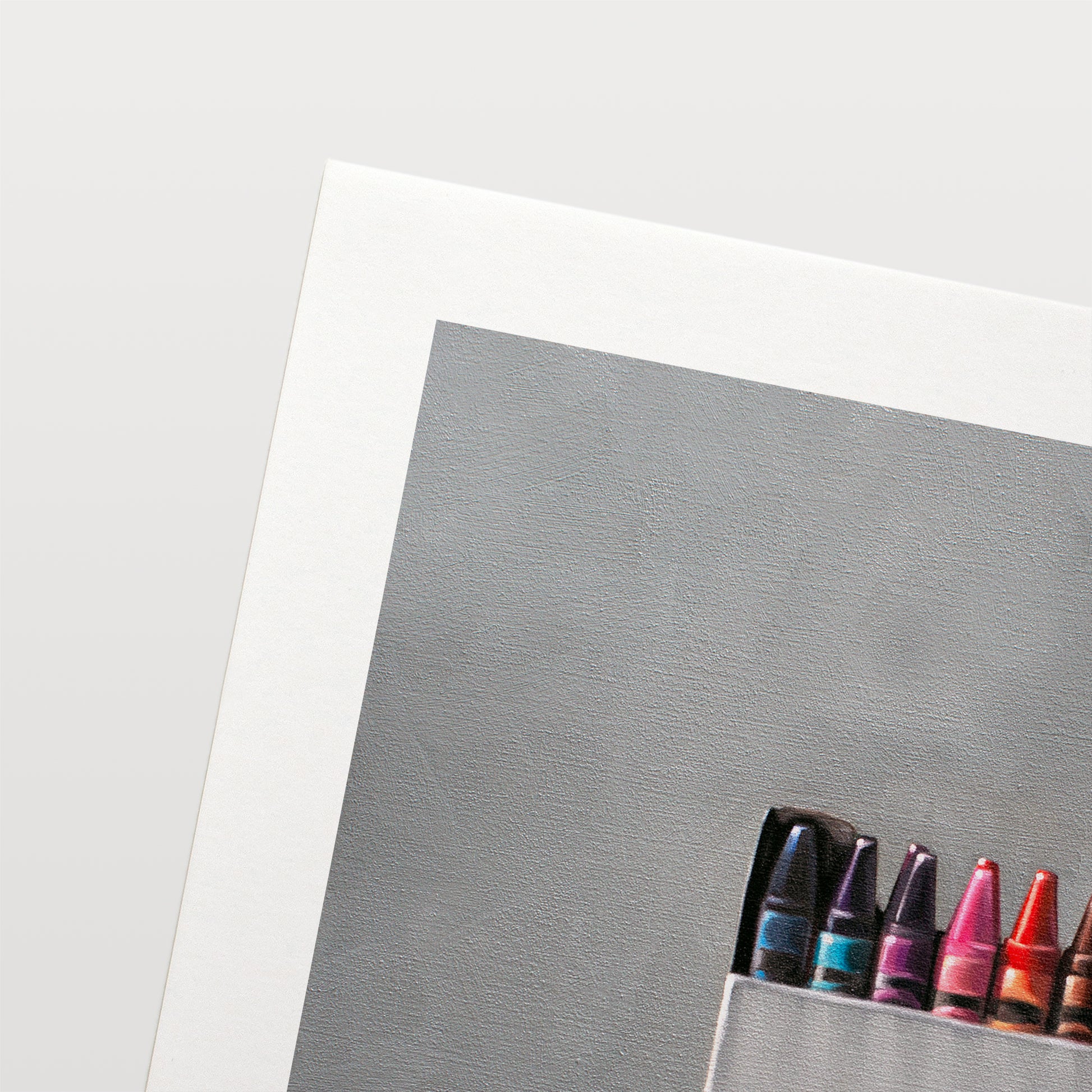 Box of Crayons Fine Art Print by Lauren Pretorius: a simple white box of crayons resting on a light reflective surface.