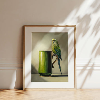 Framed fine art print of a green budgie perched on a green ceramic mug, with natural light and shadows.