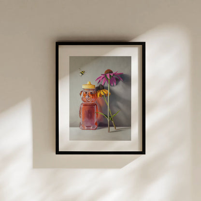 Bumble Bee, Honey & Blossoms Fine Art Print by Lauren Pretorius: a bottle of honey shaped as a bear and a pair of flowers with a bumble bee flying in to inspect.