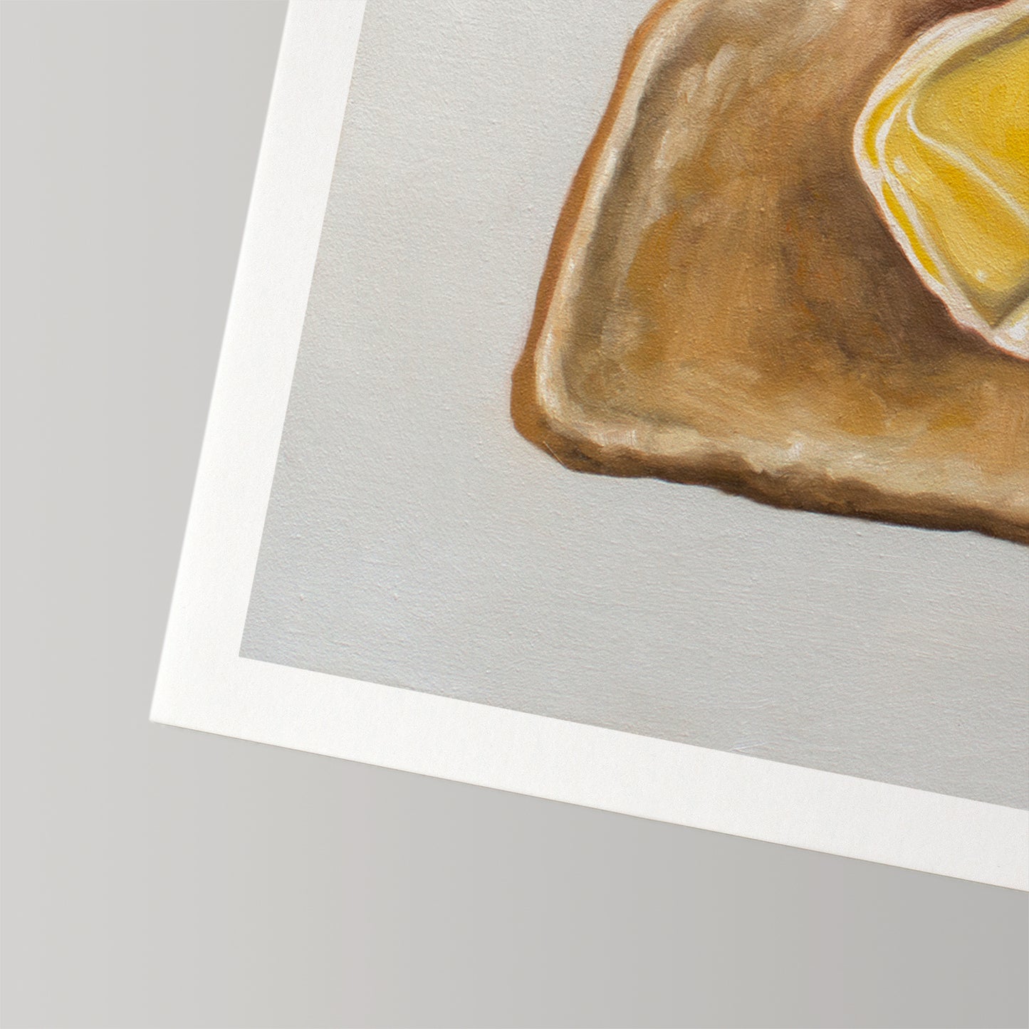 Fine art print of buttered toast with a white border on textured cotton rag paper.
