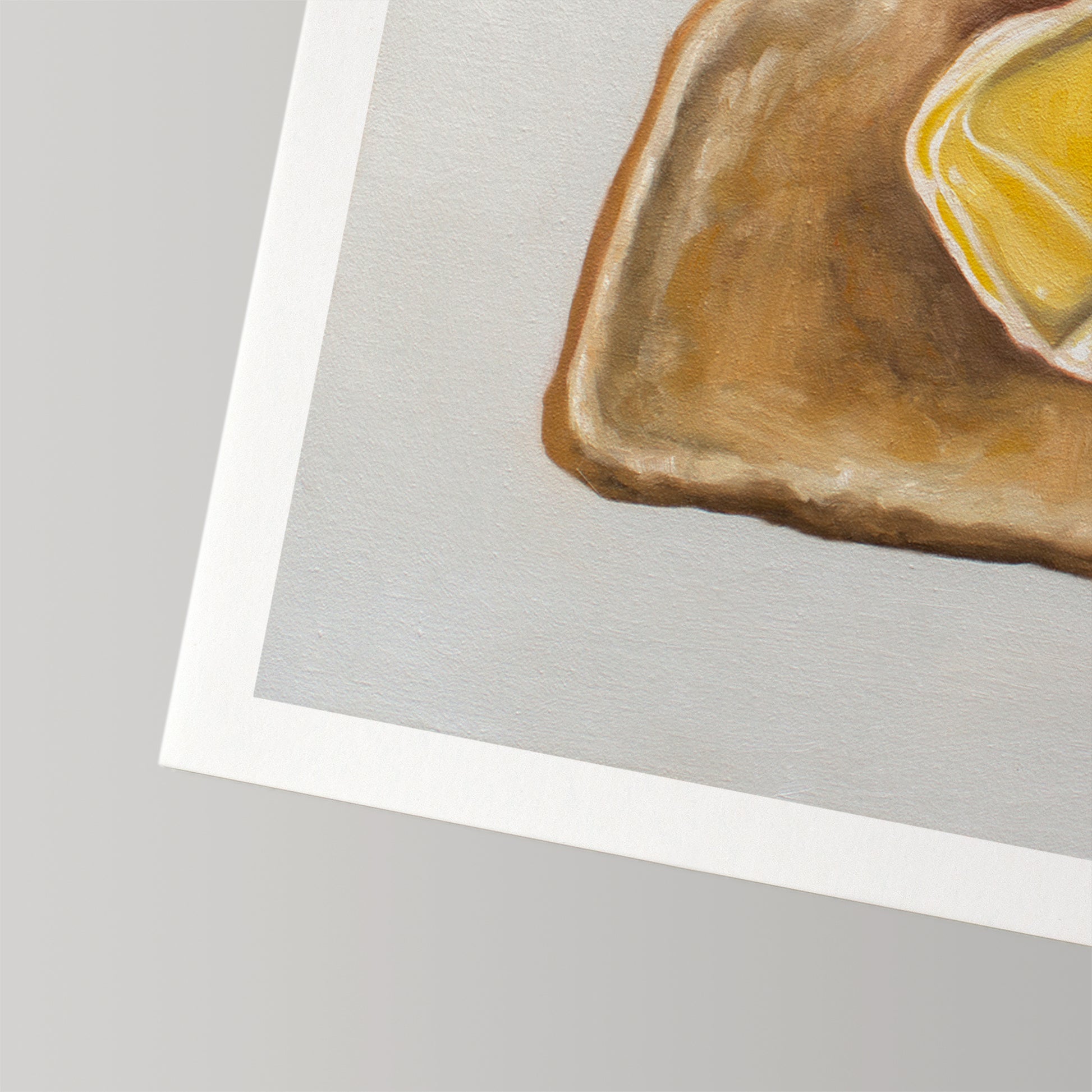 Fine art print of buttered toast with a white border on textured cotton rag paper.