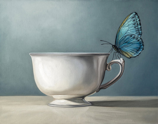 Fine art print of a vibrant blue butterfly perched on a classic white teacup against a muted blue background.