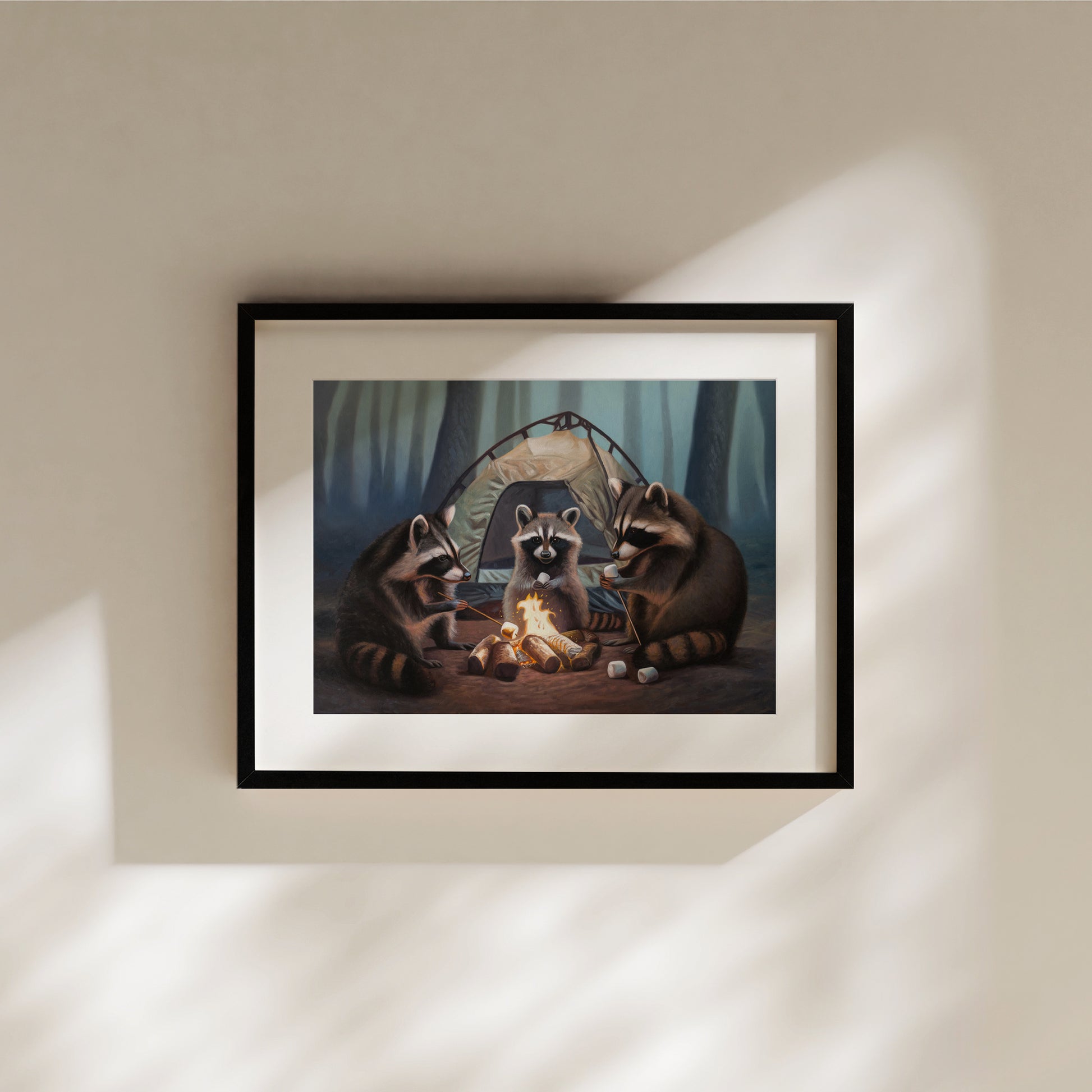 Framed art print of three raccoons roasting marshmallows around a campfire in a forest, with a tent in the background.