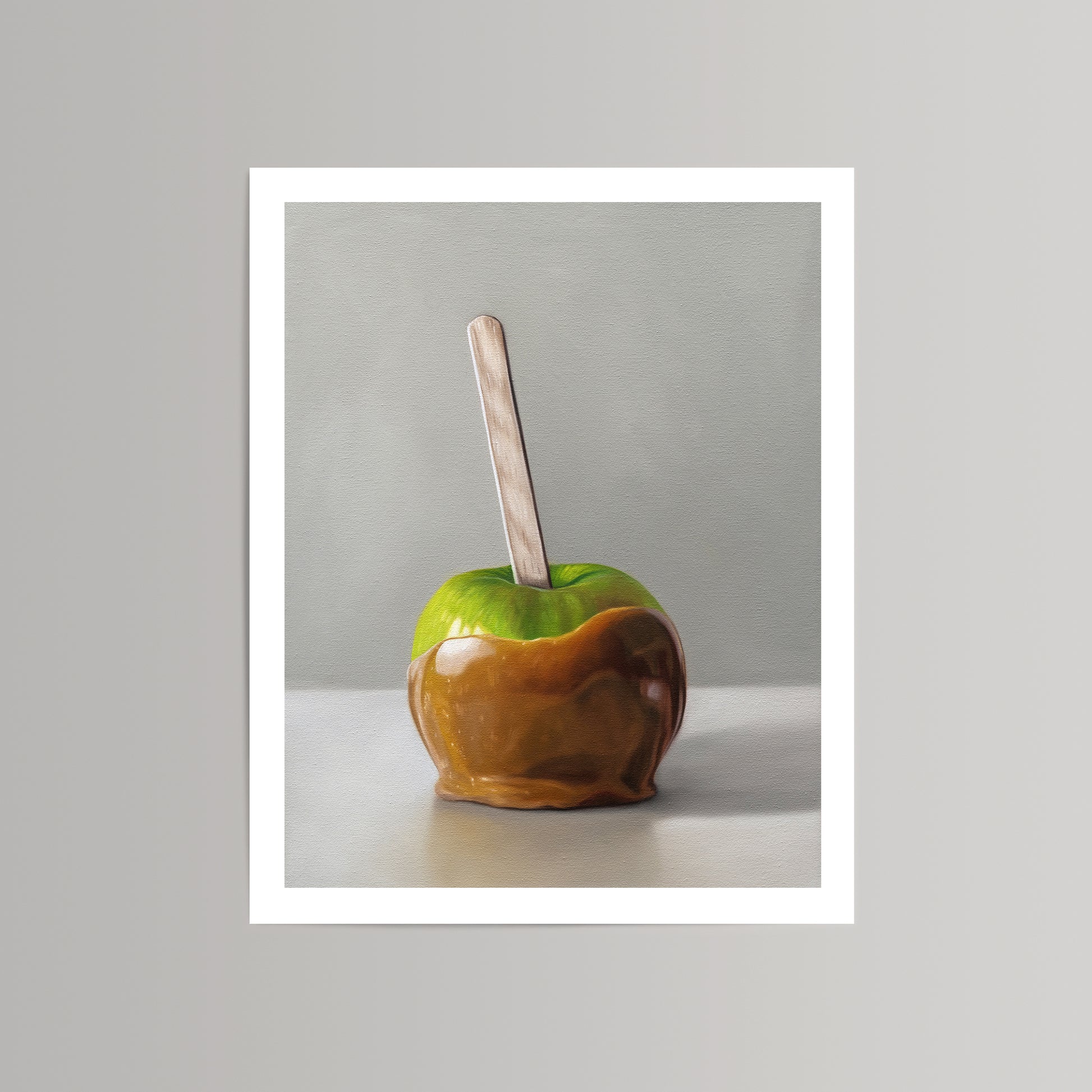 Vibrant fine art print of a green caramel apple with a wooden stick, against a neutral background.