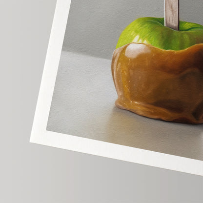 Fine art print of a vibrant green caramel apple on a stick, featuring a textured paper border.