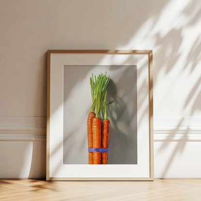 Carrot Bunch Fine Art Print by Lauren Pretorius: a bundle of carrots resting on a neutral grey surface with dramatic side lighting creating interesting cast shadows.