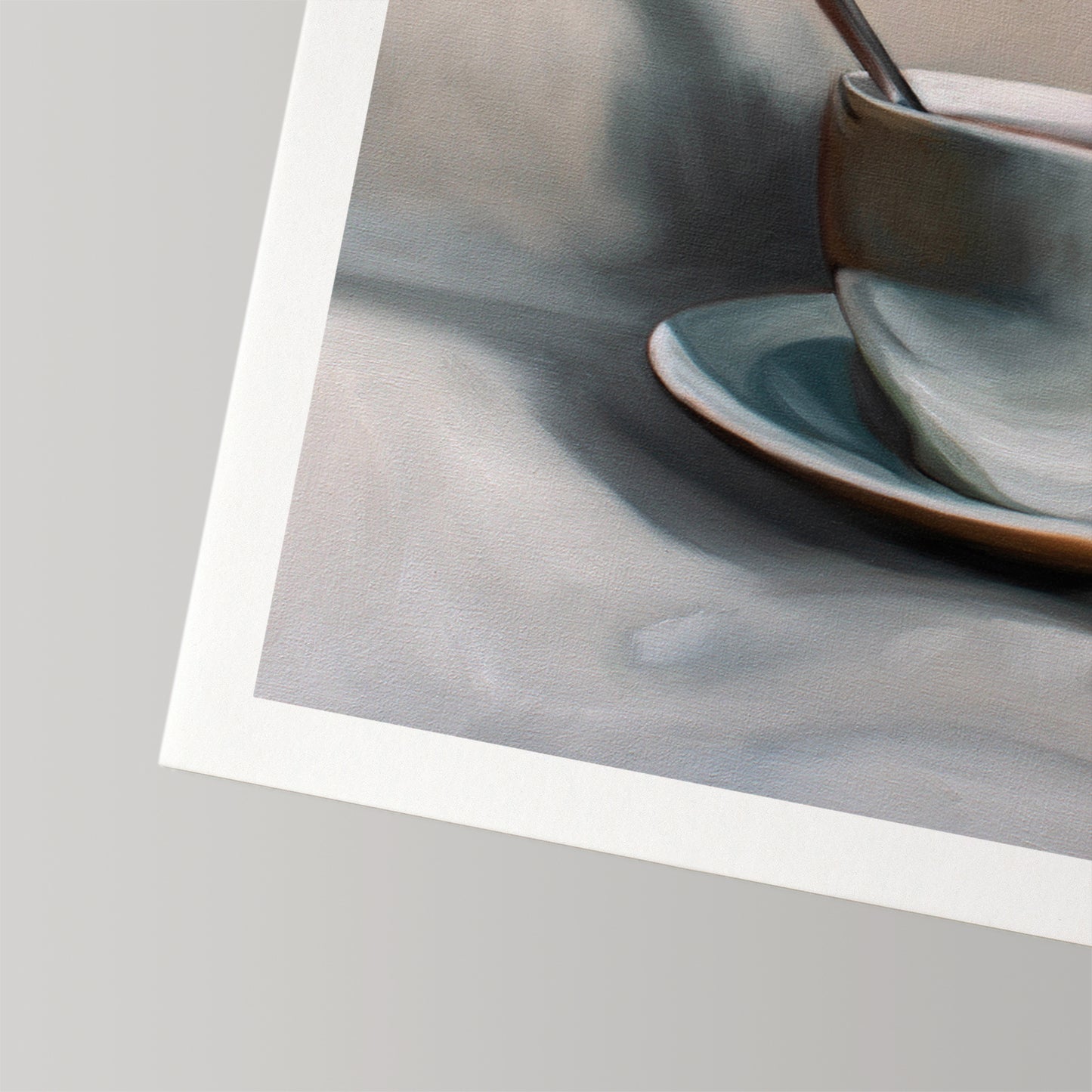 Fine art print of a light blue teacup and saucer with a spoon, on museum-grade cotton rag paper.