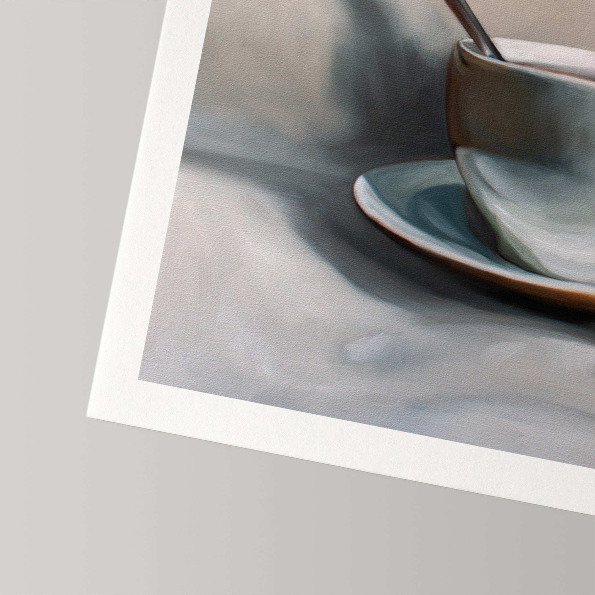 Fine art print of a light blue teacup and saucer with a spoon, on museum-grade cotton rag paper.