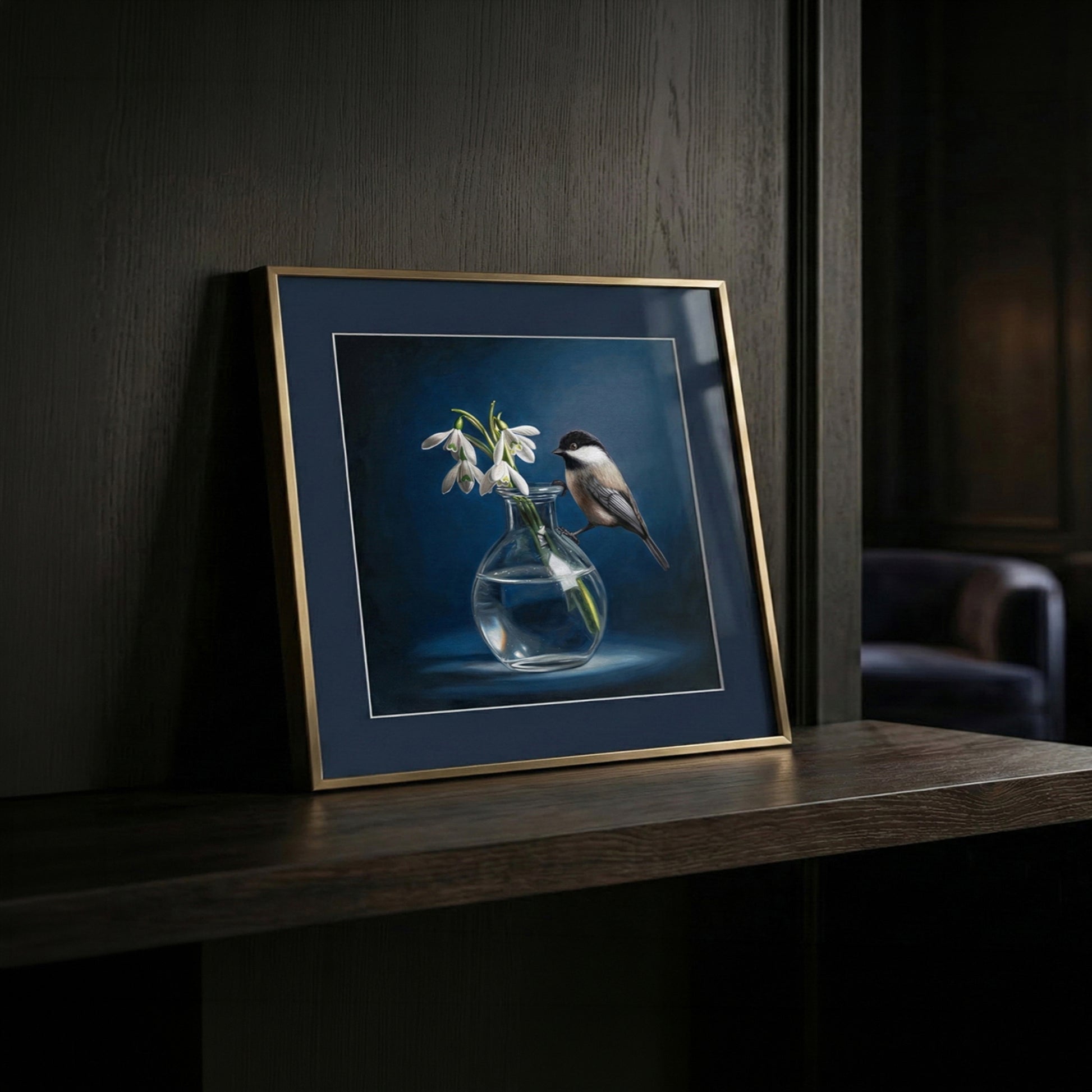 Fine art print of a chickadee perched on a clear vase with white snowdrop flowers, framed in gold.