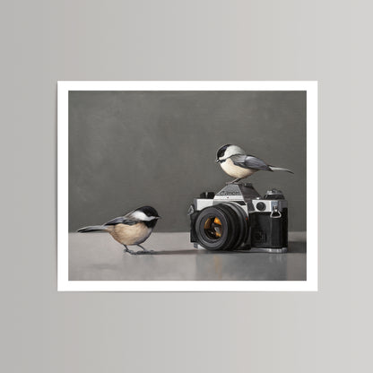 Fine art print: two black-capped chickadees, one perched on a vintage Canon camera, on a grey background.