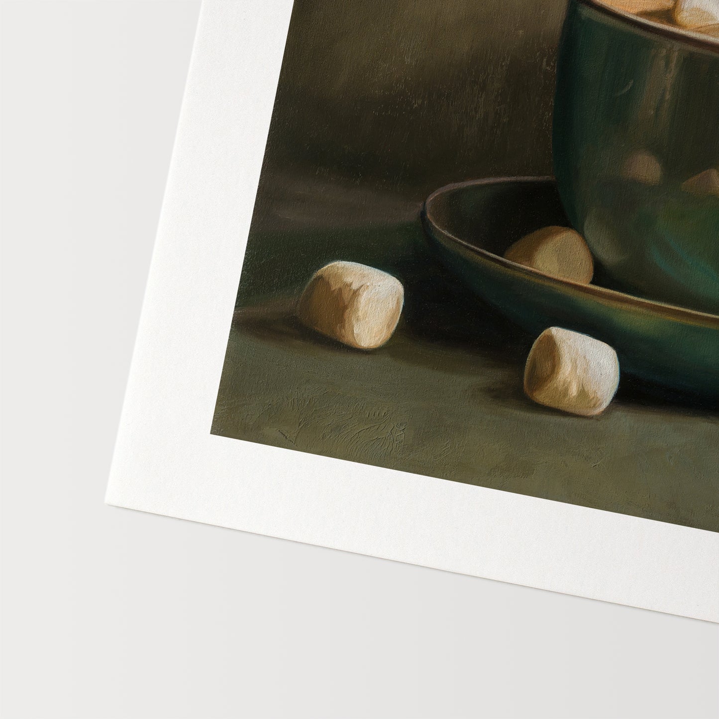 Cocoa & Marshmallows Fine Art Print by Lauren Pretorius: a green mug with marshmallows spilling out, placed on a surface with a shadow falling over part of the image.