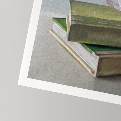 Fine art print of a stack of green and beige books on a grey surface, with a white border.