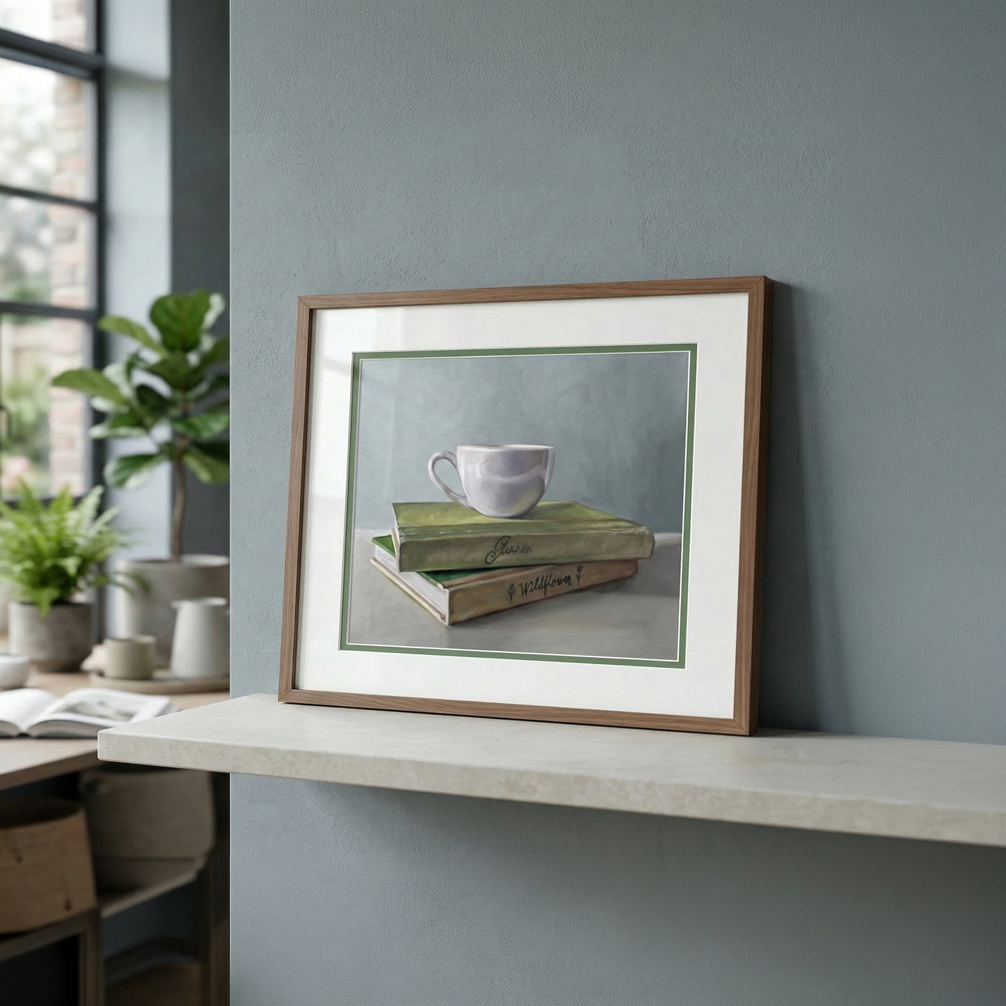 Fine art print of a purple coffee cup stacked on green books, framed in wood, on a modern shelf.