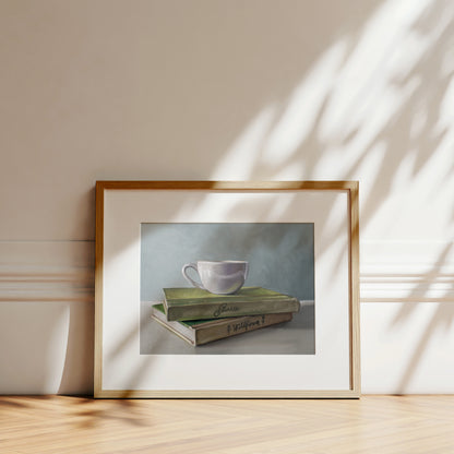 Framed fine art print of a white teacup on two green books, with soft shadows.