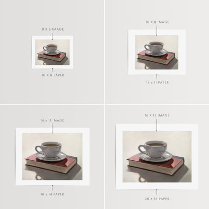 Coffee & Book Fine Art Print by Lauren Pretorius: a backlit coffee cup and saucer resting on top of a red book.