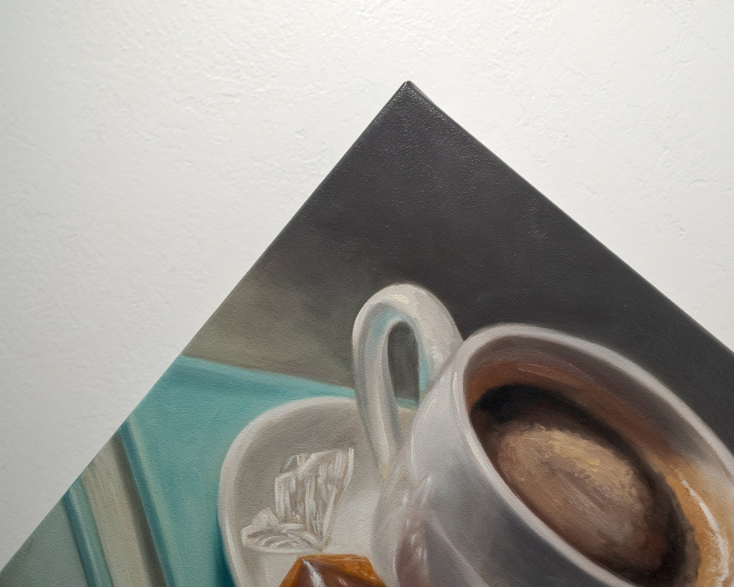 Coffee, Caramel & Book 12" x 12" Original Oil Painting by Lauren Pretorius: a white cup of coffee with a saucer on top of a book, with a piece of caramel on the saucer.