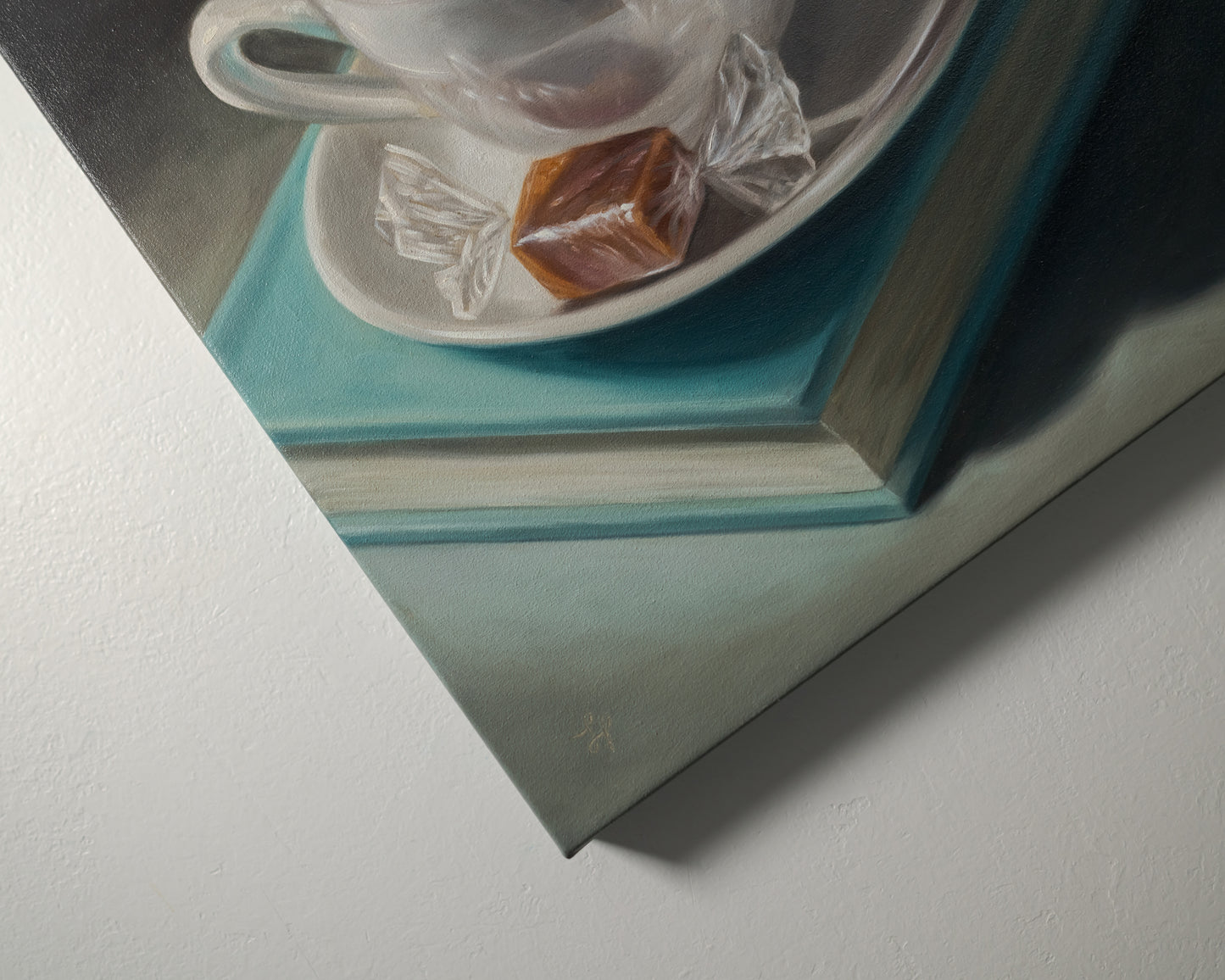 Coffee, Caramel & Book 12" x 12" Original Oil Painting by Lauren Pretorius: a white cup of coffee with a saucer on top of a book, with a piece of caramel on the saucer.