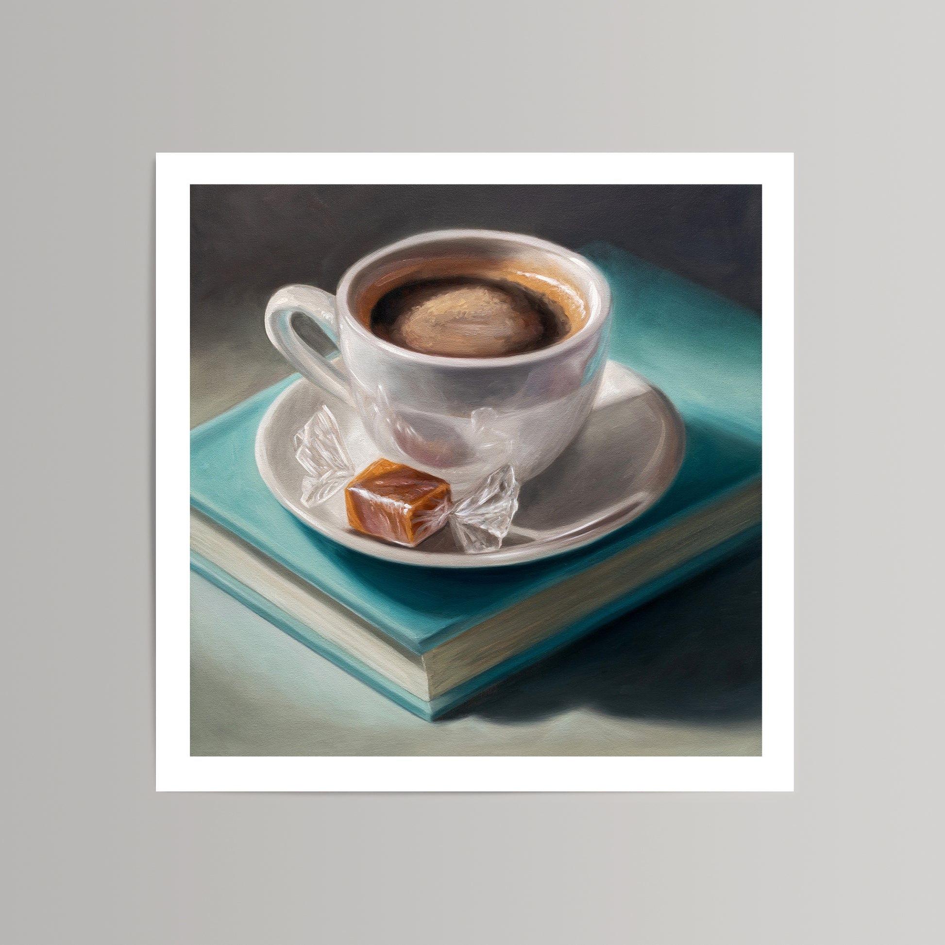 Fine art print of a white coffee cup with caramel candy on teal books.