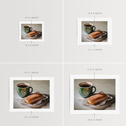 Coffee & Maple Bar Donut Fine Art Print by Lauren Pretorius: a coffee cup and a maple bar donut placed on a paper wrapper, with a cup of coffee.