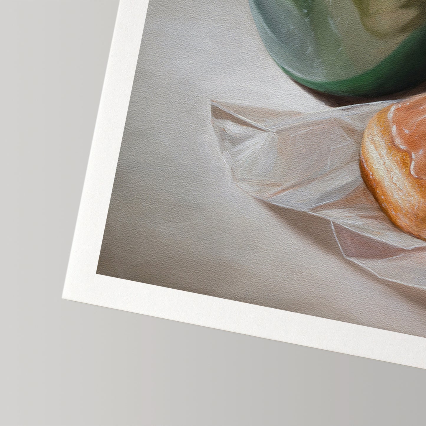 Fine art print of a warm glazed donut on white paper, next to a green coffee cup.