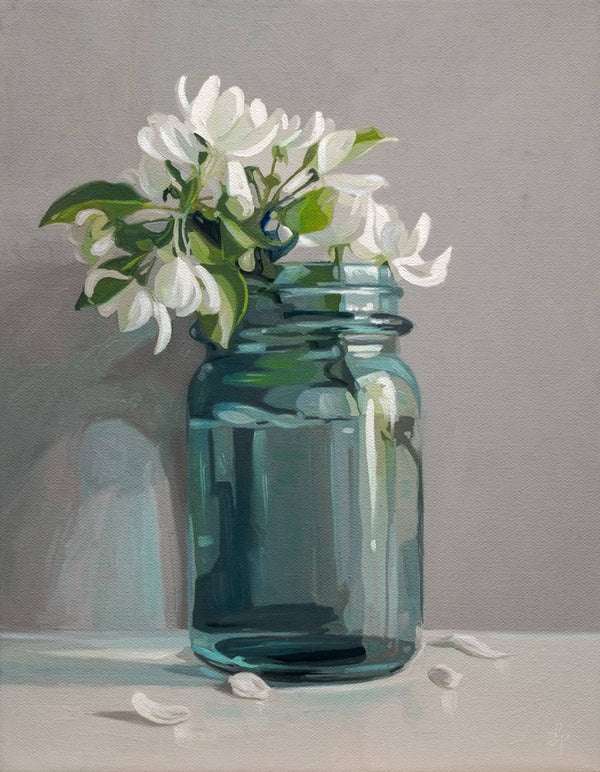 Blue glass jar with white flowers on a gray background