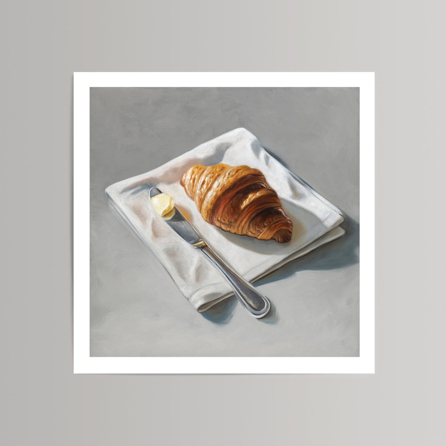 Fine art print of a golden croissant, butter pat, and silver knife on a white napkin, set against a gray background.