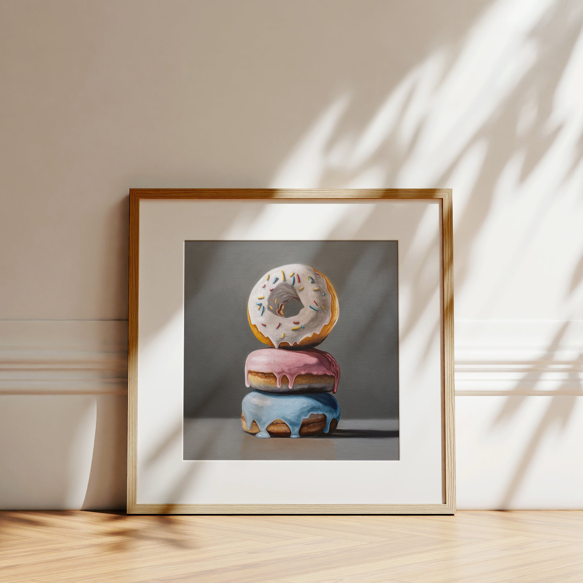 Donut Stack Trio Fine Art Print by Lauren Pretorius: a trio of donuts with different colored frosting stacked top of each other.