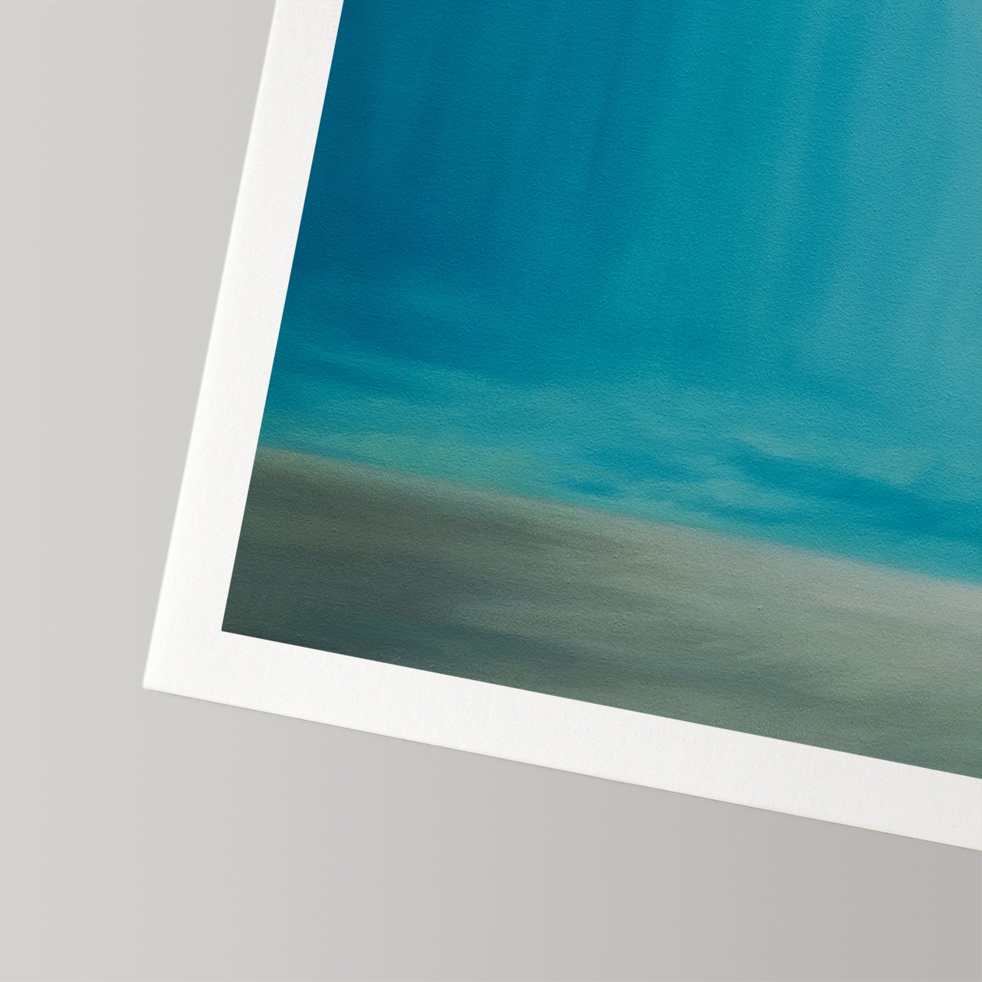 Close-up of a fine art print with a blue and grey abstract design and a white border on cotton rag paper.