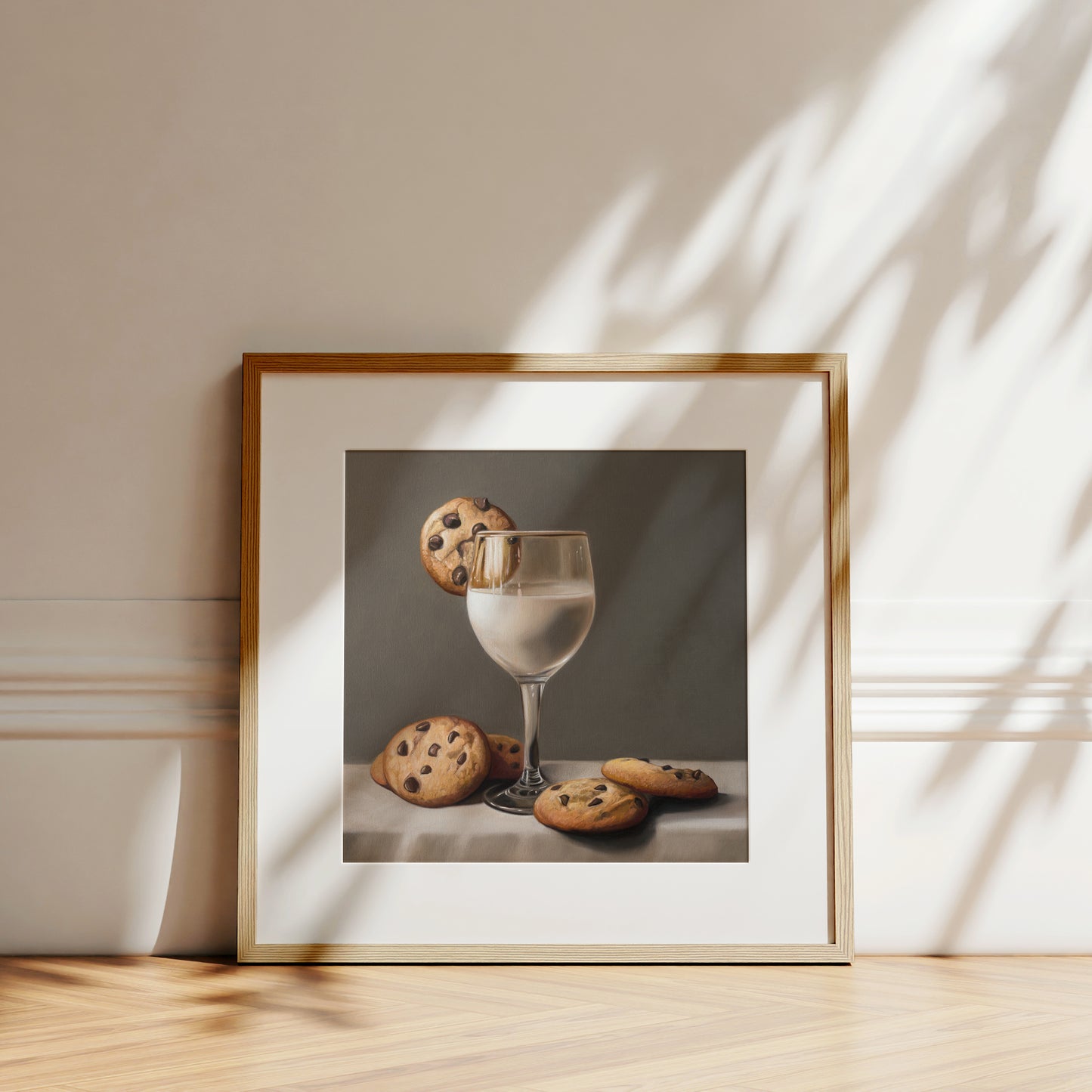 Framed fine art print of a glass of milk with chocolate chip cookies on a white table.