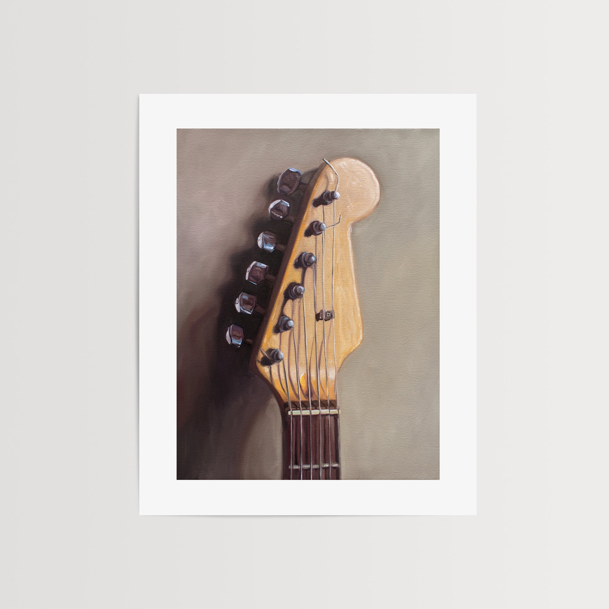 Fender Stratocaster Guitar Head Stock Fine Art Print by Lauren Pretorius: an electric guitar head stock leaning on a warm grey surface with some nice dramatic lighting.