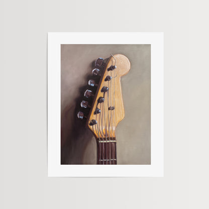 Fender Stratocaster Guitar Head Stock Fine Art Print by Lauren Pretorius: an electric guitar head stock leaning on a warm grey surface with some nice dramatic lighting.