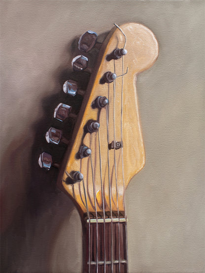 Fender Stratocaster Guitar Head Stock Fine Art Print by Lauren Pretorius: an electric guitar head stock leaning on a warm grey surface with some nice dramatic lighting.