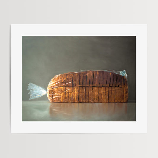 Fresh Bread Loaf Fine Art Print by Lauren Pretorius: a fresh loaf of bread in clear plastic wrap on a medium grey background.