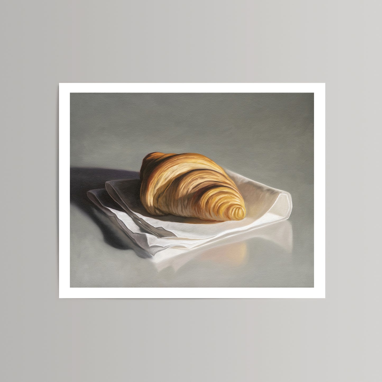 Still life fine art print of a golden croissant on a white napkin, set against a grey background.