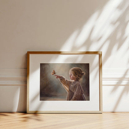 Girl with Butterfly Fine Art Print by Lauren Pretorius: a young girl reaching out to touch a butterfly against a soft, blurred background.