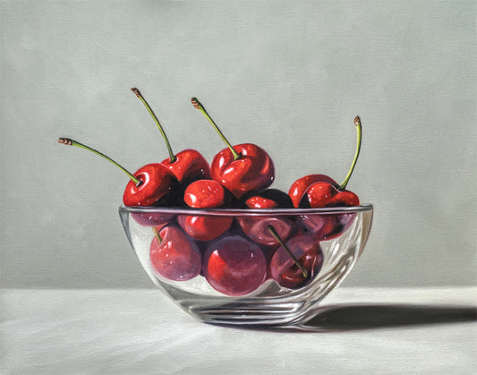 Still life fine art print of vibrant red cherries in a clear glass bowl on a light background.