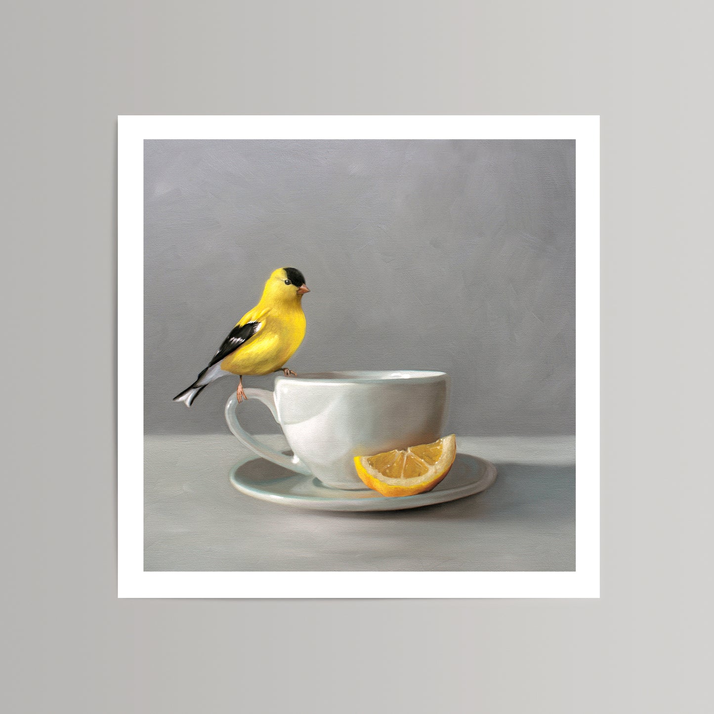 Fine art print of a vibrant yellow goldfinch perched on a white teacup with a lemon slice.