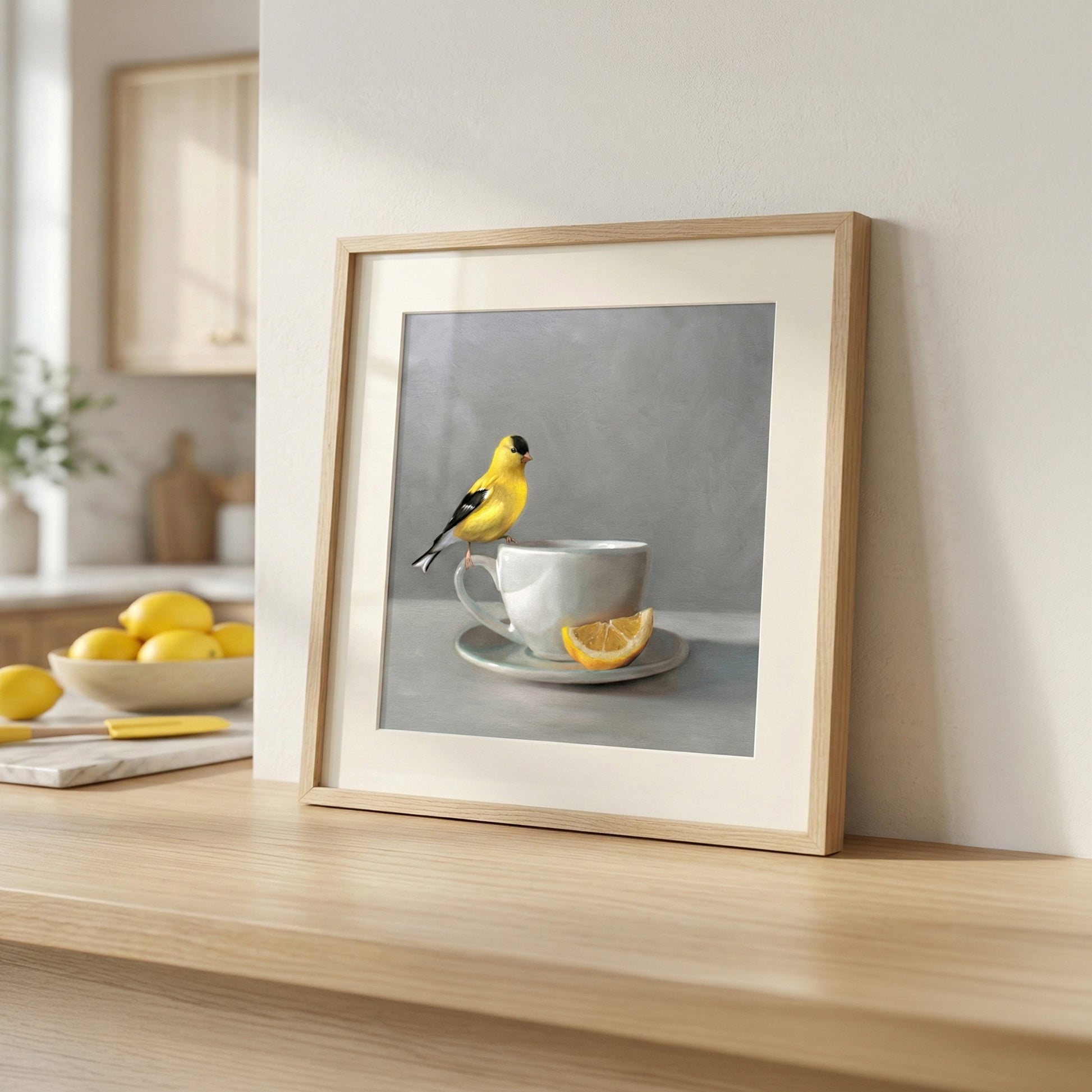 Framed fine art print of a yellow goldfinch perched on a white teacup with a lemon slice.