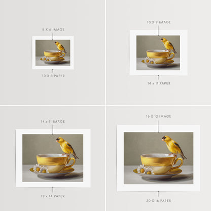 Goldfinch & Yellow Cup Fine Art Print by Lauren Pretorius: a goldfinch perched on a gold teacup with white flowers on a saucer against a neutral background