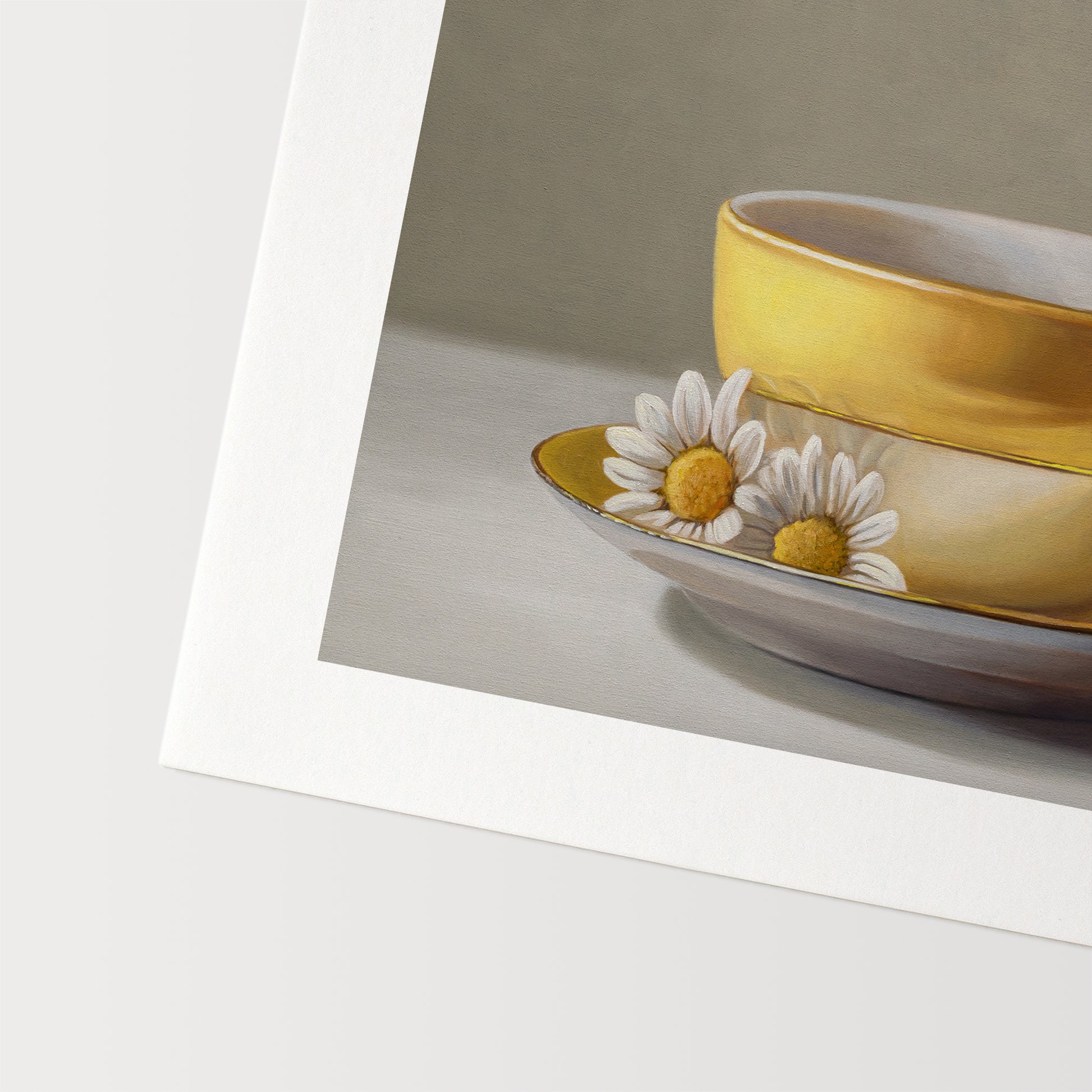 Goldfinch & Yellow Cup Fine Art Print by Lauren Pretorius: a goldfinch perched on a gold teacup with white flowers on a saucer against a neutral background