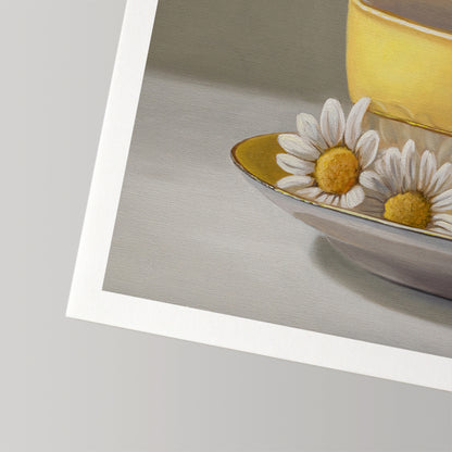 Close-up of a fine art print featuring a yellow teacup and saucer with two white daisies.