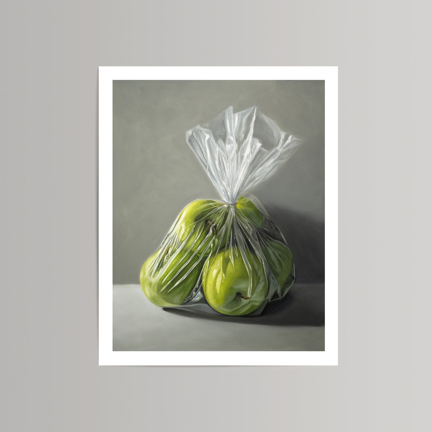 Realistic fine art print of bright green Granny Smith apples in a clear plastic bag on a gray background.