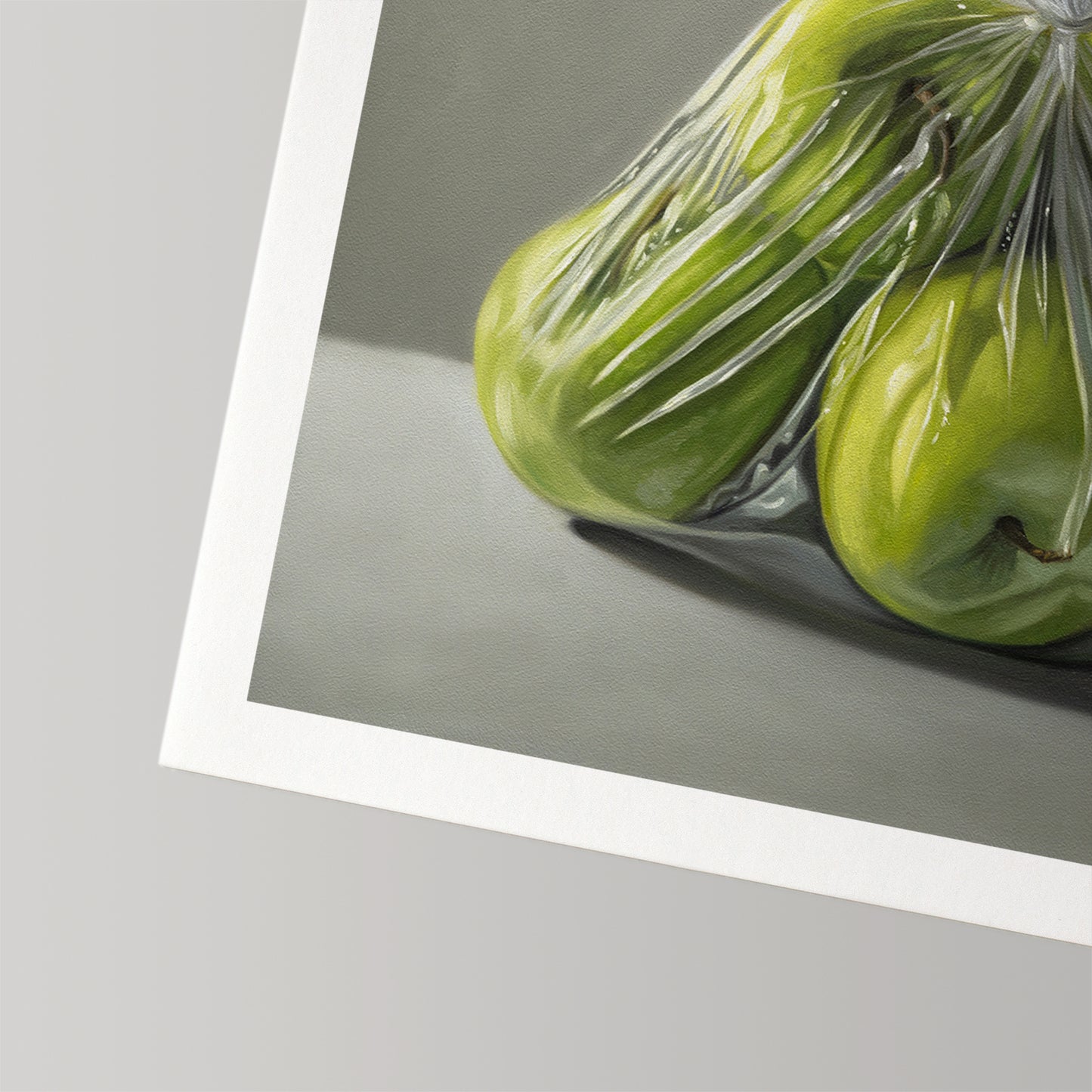 Fine art print of vibrant green Granny Smith apples in a clear plastic bag, with a white border.