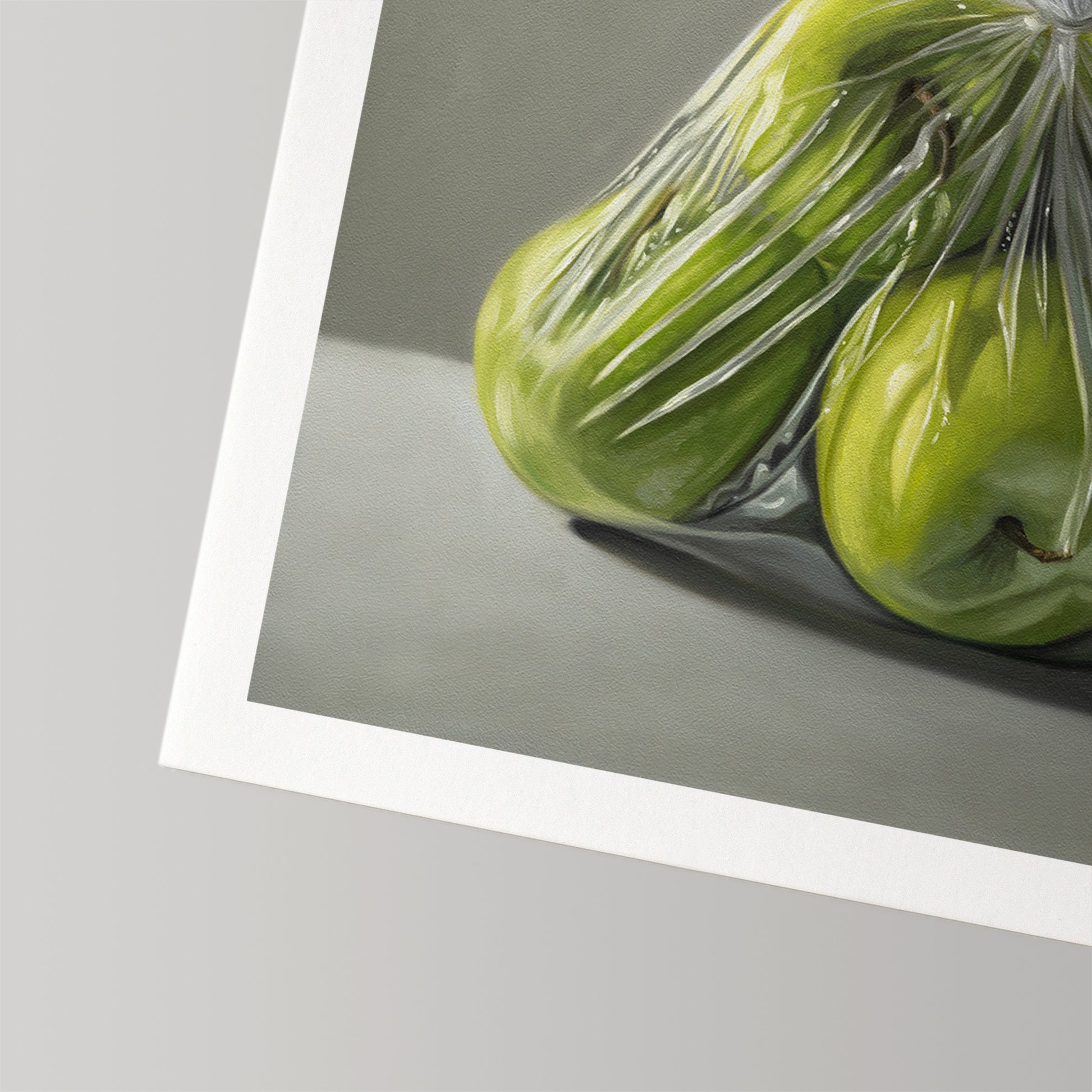 Fine art print of vibrant green Granny Smith apples in a clear plastic bag, with a white border.