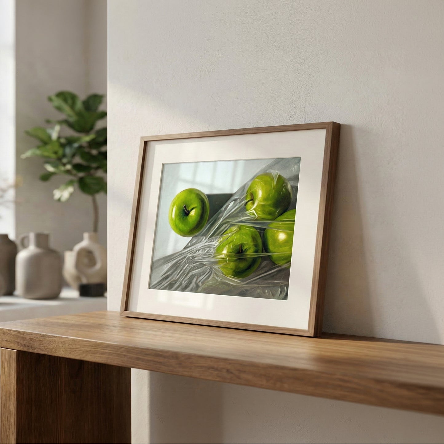 Granny Smith Apples fine art print in a brown wood frame, featuring vibrant green apples wrapped in plastic.