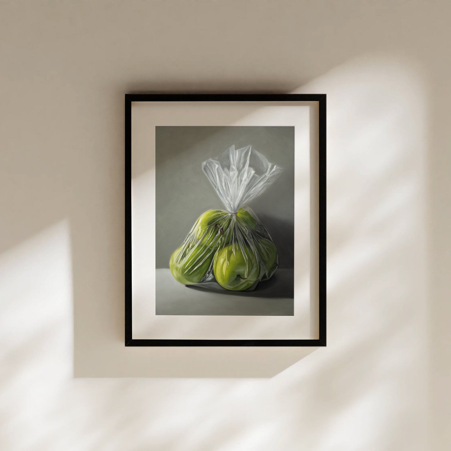 Framed fine art print of three vibrant green Granny Smith apples in a clear plastic bag.