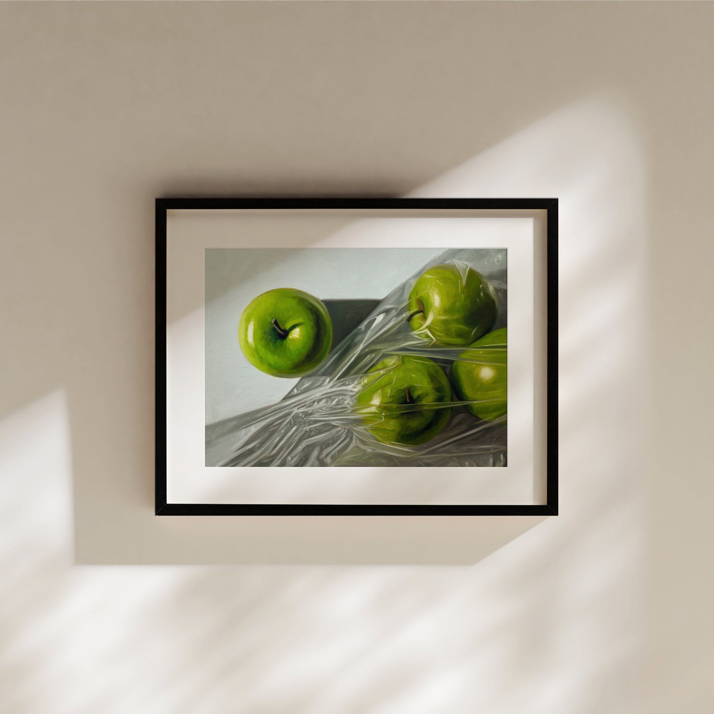 Framed fine art print of four vibrant green Granny Smith apples, one unwrapped, three in plastic.
