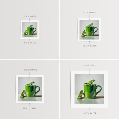 Green Frogs & Cup Fine Art Print by Lauren Pretorius: a green frog on a green mug against a light gray background